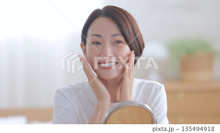 鏡を見て微笑む女性 135494918