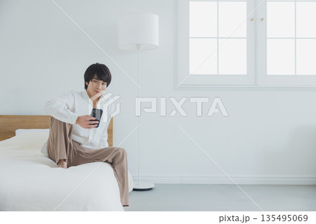 ベッドでスマホを見る男性 ベッドでスマホを見る男性 135495069