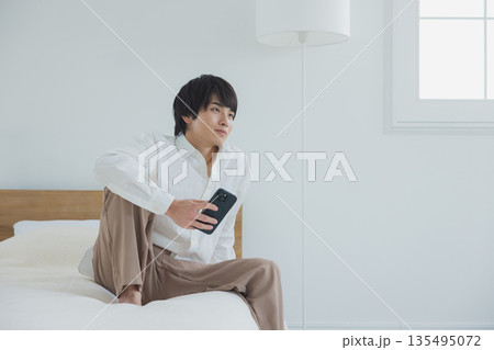 ベッドでスマホを見る男性 ベッドでスマホを見る男性 135495072