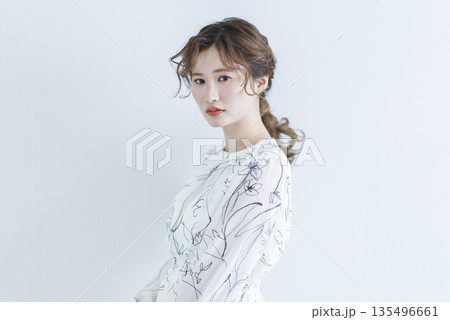 白背景に立つワンピースを着た若い女性 白背景に立つワンピースを着た若い女性 135496661
