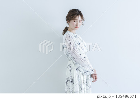 白背景に立つワンピースを着た若い女性 135496671