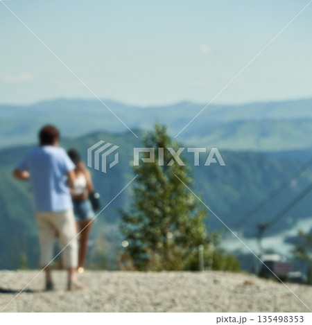 Caucasian young adults enjoy scenic mountain view on a sunny day Caucasian young adults enjoy scenic mountain view on a sunny day 135498353