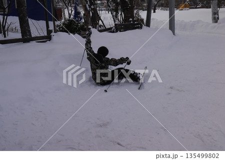 スキーで転ぶ男の子(後ろ姿) 135499802