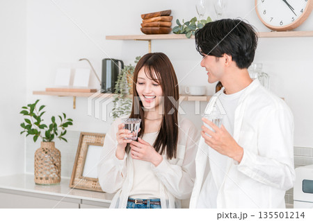キッチンで水を飲む若いアジア人カップル,夫婦 キッチンで水を飲む若いアジア人カップル,夫婦 135501214
