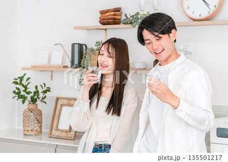 キッチンで水を飲む若いアジア人カップル,夫婦 キッチンで水を飲む若いアジア人カップル,夫婦 135501217
