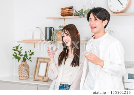 キッチンで水を飲む若いアジア人カップル,夫婦 キッチンで水を飲む若いアジア人カップル,夫婦 135501219