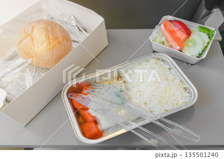 Lunch on the plane - rice, fresh fish and salad with a bun. High quality photo 135501240