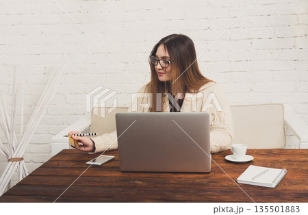 Online shopping at home. Girl holding credit card looking at laptop. buying in internet, e-commerce concept. 135501883