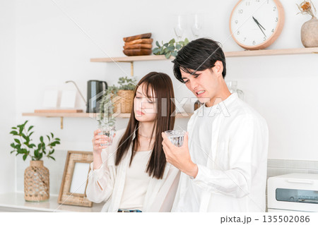 キッチンで水道水が不味くて困っている若いアジア人夫婦,カップル キッチンで水道水が不味くて困っている若いアジア人夫婦,カップル 135502086