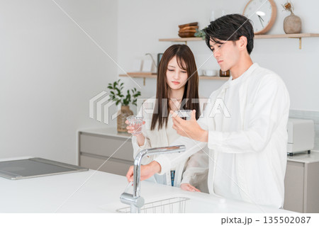 キッチンで水道水が不味くて困っている若いアジア人夫婦,カップル 135502087