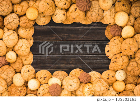 Cookies frame background. Sweet chocolate chips biscuits on brown rustic wood with copy space. Cookies frame background. Sweet chocolate chips biscuits on brown rustic wood with copy space. 135502163