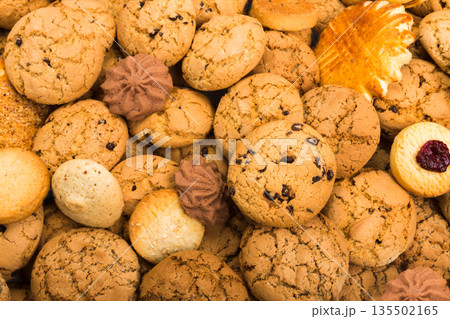 Cookies background. Sweet chocolate chips biscuits, shortbread with jam texture background. Oatmeal, chocolated drops and other sweets. 135502165