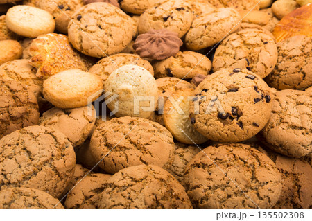 Cookies background. Sweet chocolate chips biscuits, shortbread with jam texture background. Oatmeal, chocolated drops and other sweets. Cookies background. Sweet chocolate chips biscuits, shortbread with jam texture background. Oatmeal, chocolated drops and other sweets. 135502308