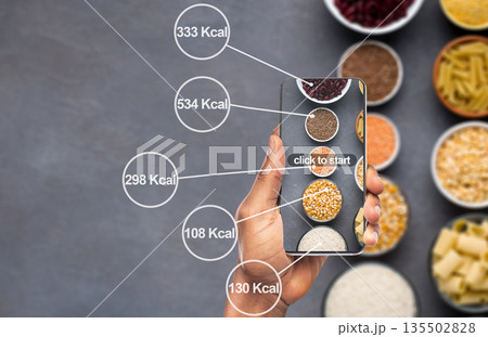 Losing weight easily. Cellphone counting amount of calories on background with cereals and pasta Losing weight easily. Cellphone counting amount of calories on background with cereals and pasta 135502828