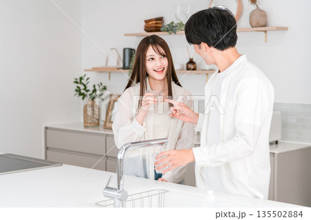 キッチンで水を飲む笑顔のカップル,夫婦(浄水器,水道水) キッチンで水を飲む笑顔のカップル,夫婦(浄水器,水道水) 135502884