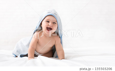 Happy baby crawling on bed after bath, babycare, copy space 135503206