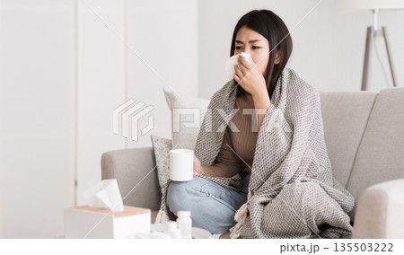Folk Medicine. Sick Girl with Fever Wrapped in Blanket Drinking Hot Tea and Blowing Nose, Free Space 135503222
