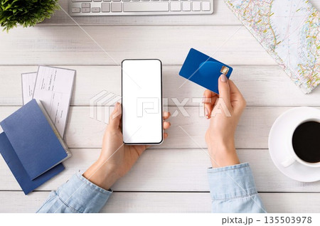 Preparing for travel. Woman using smartphone with blank screen and credit card for booking hotel, mockup Preparing for travel. Woman using smartphone with blank screen and credit card for booking hotel, mockup 135503978