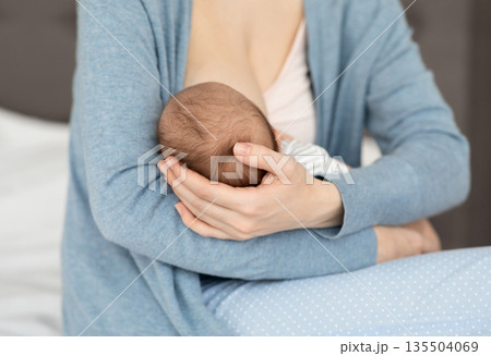 Unrecognizable Mother Holding And Breastfeeding Newborn Baby At Home, Loving Mom Tenderly Holding Head Of Her Infant Child During Lactation, Bonding With Small Kid, Closeup Shot, Cropped Unrecognizable Mother Holding And Breastfeeding Newborn Baby At Home, Loving Mom Tenderly Holding Head Of Her Infant Child During Lactation, Bonding With Small Kid, Closeup Shot, Cropped 135504069