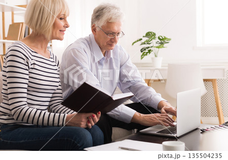 Mature Couple Checking Domestic Finances And Calculating Bills Using Laptop Mature Couple Checking Domestic Finances And Calculating Bills Using Laptop 135504235