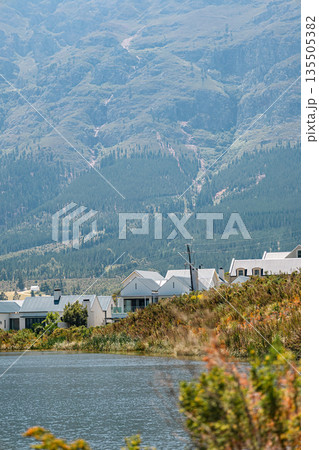 houses near a tranquil lake with grand mountain backdrop 135505382