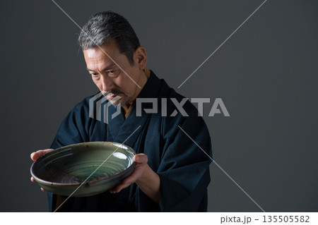 皿を持つ陶芸家の男性 135505582