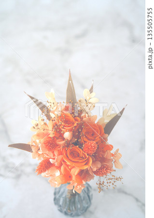 花瓶に入ったオレンジのブーケ(大理石背景) 135505755