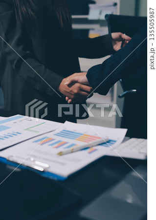 Young business people shaking hands in the office. Finishing successful meeting. Three persons. Wide screen panoramic Young business people shaking hands in the office. Finishing successful meeting. Three persons. Wide screen panoramic 135505987