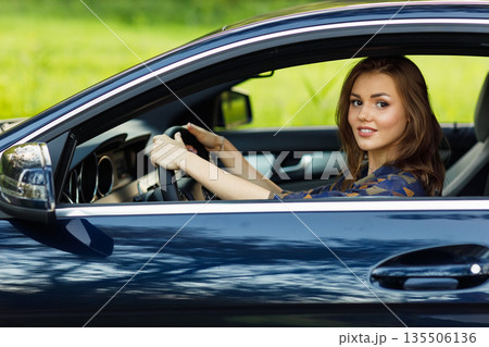 Happy woman driver at car smiling. Cute young happy brunette female driving car vehicle Happy woman driver at car smiling. Cute young happy brunette female driving car vehicle 135506136