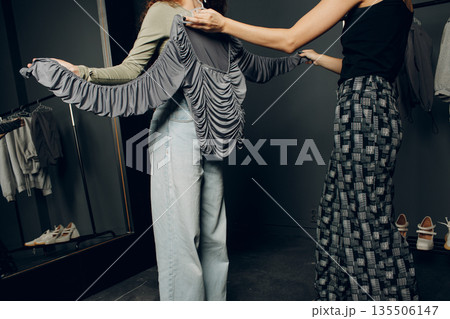 Stylist designer helping choose clothes dress to customer client 135506147