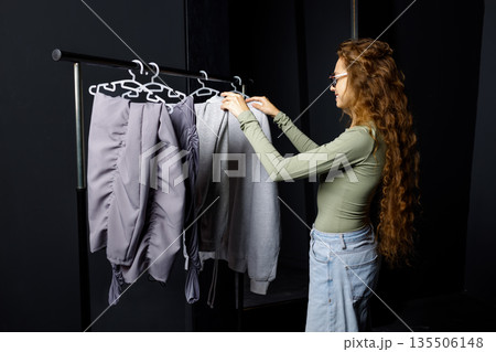 Young woman choosing clothes at fitting room. Shopping concept Young woman choosing clothes at fitting room. Shopping concept 135506148
