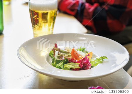 白い大皿に盛り付けられた彩り野菜のヘルシーサラダ 135506800