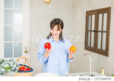 キッチンで野菜を持っている女性 135506879