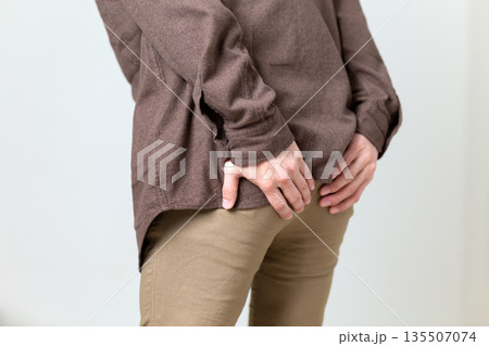 お尻を押さえて苦しむミドル男性 135507074