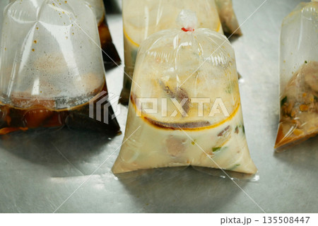 Liquid viands bags plastic and soups from street stalls in Thailand are typically packed in thick cellophane detail, which are securely package sealed with knots close-up. Reduces pack recyclability 135508447