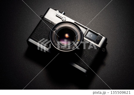 暗い背景にスポットライトが当たった古いフィルムカメラ 暗い背景にスポットライトが当たった古いフィルムカメラ 135509621