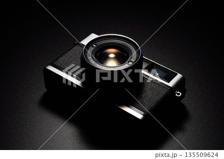 暗い背景にスポットライトが当たった古いフィルムカメラ 135509624