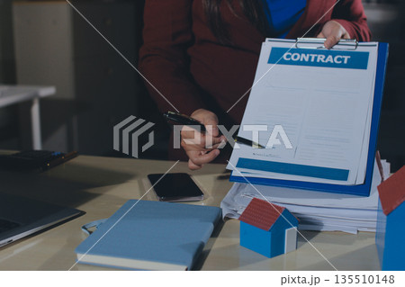 Customer signing a real estate contract in real estate agency. Customer signing a real estate contract in real estate agency. 135510148