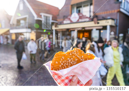 Classic Stroopwafel in hand. Traditional sweet food stroopwafels with caramel in Holland Volendam Netherlands Classic Stroopwafel in hand. Traditional sweet food stroopwafels with caramel in Holland Volendam Netherlands 135510157