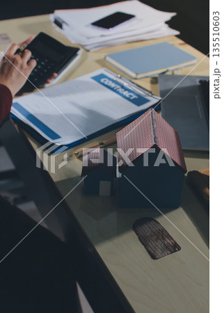 Customer signing a real estate contract in real estate agency. Customer signing a real estate contract in real estate agency. 135510603