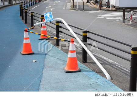 自転車専用レーンの標識ポールが折れて倒れた道路の様子 135510997