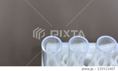 試験管立てに並ぶプラスチック製試験管の開口部クローズアップ 医療・検査イメージ 135511407