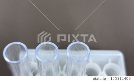 試験管立てに並ぶプラスチック製試験管3本の開口部クローズアップ 医療・検査イメージ 135511409