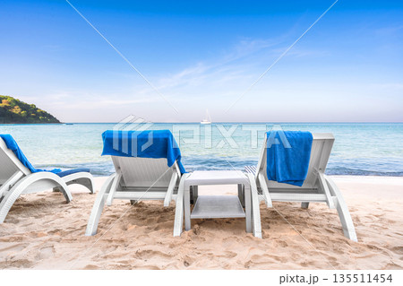Row of sun loungers with blue towels on a quiet tropical beach at Ao Prao, Koh Samed, Thailand Row of sun loungers with blue towels on a quiet tropical beach at Ao Prao, Koh Samed, Thailand 135511454