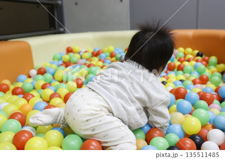 ボールプールで遊ぶ0歳児の後ろ姿。室内遊び。 135511485