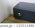 畳の和室に設置された黒い家庭用金庫。 135511486