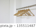 白を基調とした空のクローゼットと複数の木製ハンガー。 135511487