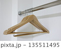 白を基調とした空のクローゼットと複数の木製ハンガー。 135511495