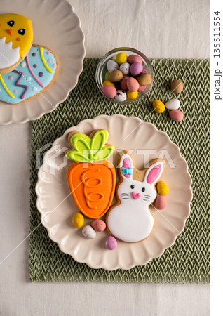 Easter festive colourful cookies bunny, carrot, egg, chick in a plate with egg candies. Easter festive colourful cookies bunny, carrot, egg, chick in a plate with egg candies. 135511554