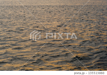 Golden light reflects off the gentle waves of the Bosphorus strait, creating a peaceful atmosphere as the sun sets on the horizon in the evening. Golden light reflects off the gentle waves of the Bosphorus strait, creating a peaceful atmosphere as the sun sets on the horizon in the evening. 135513860